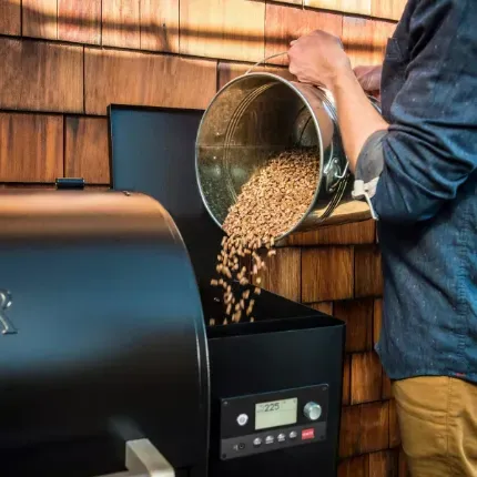 person loading grill with pellets